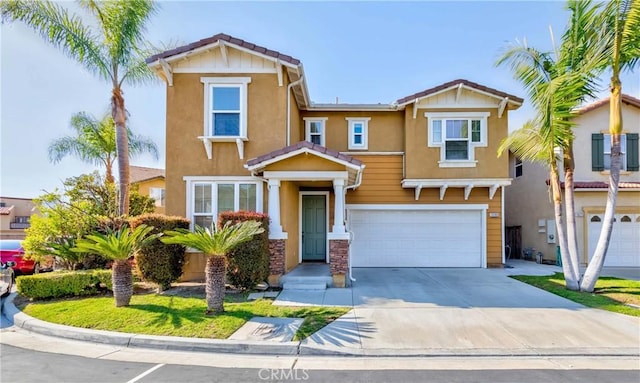 view of front of property with stucco siding, a tiled roof, concrete driveway, and a garage