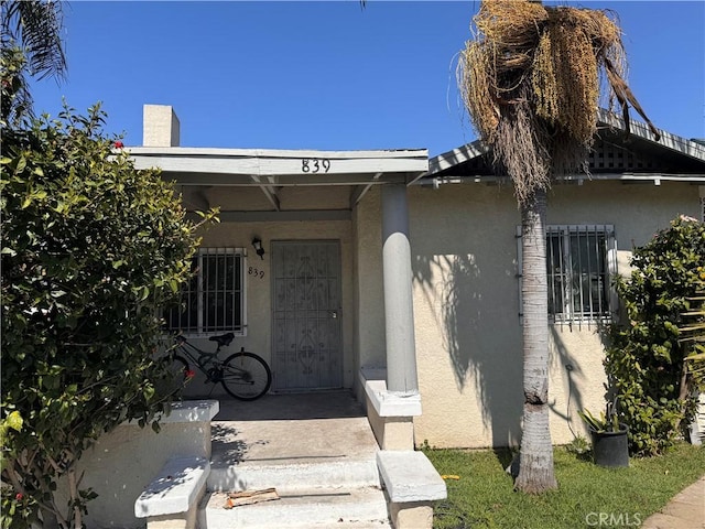 view of exterior entry with stucco siding