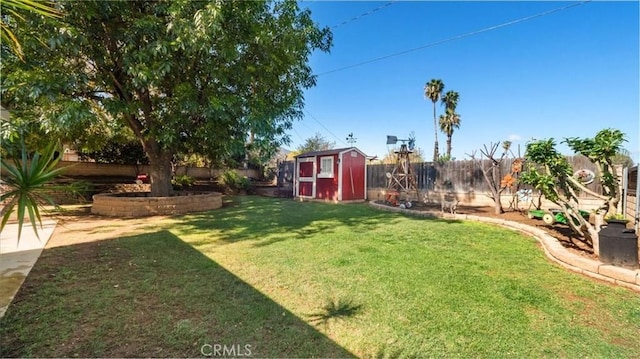 view of yard with an outbuilding, a fenced backyard, and a shed