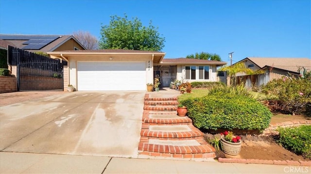 single story home with a gate, an attached garage, fence, and driveway