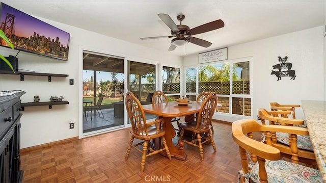 dining area with a ceiling fan and baseboards