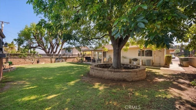 view of yard featuring a patio, a fenced backyard, central AC, and a fire pit