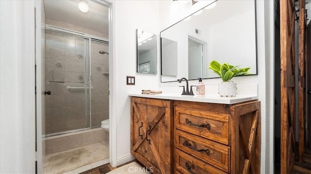 full bathroom with visible vents, a shower stall, toilet, and vanity