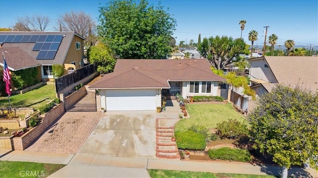 single story home featuring an attached garage, concrete driveway, a front lawn, and fence