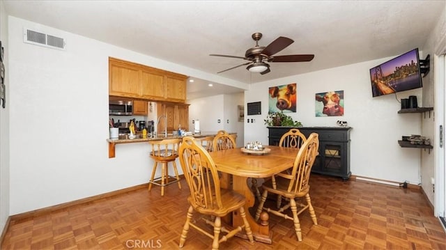 dining space featuring baseboards, visible vents, and ceiling fan