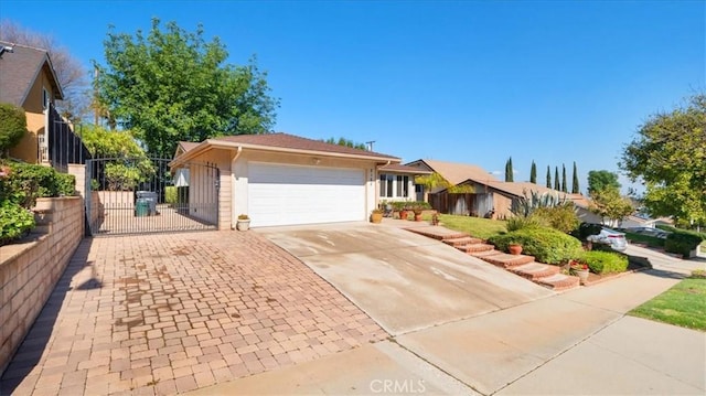 ranch-style home with a garage, fence, driveway, and a gate