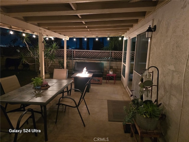 patio at twilight featuring a grill, an outdoor fire pit, outdoor dining area, and a fenced backyard