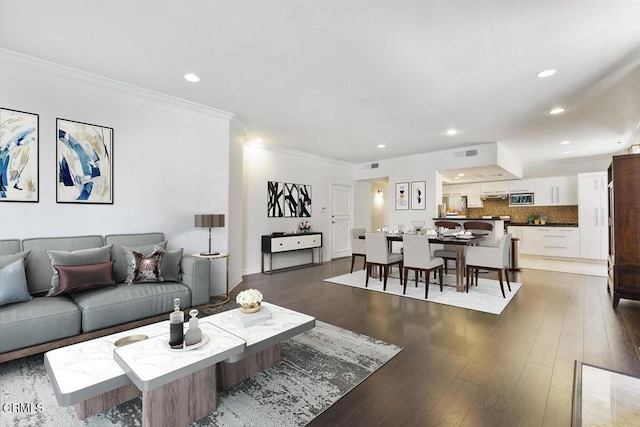 living area featuring recessed lighting, wood finished floors, visible vents, and ornamental molding