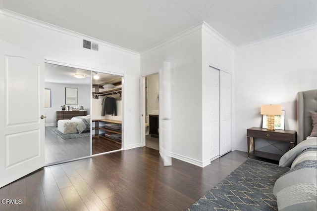 bedroom with visible vents, baseboards, and wood finished floors