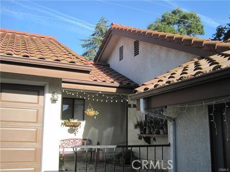 view of side of home featuring stucco siding, an attached garage, and a tile roof