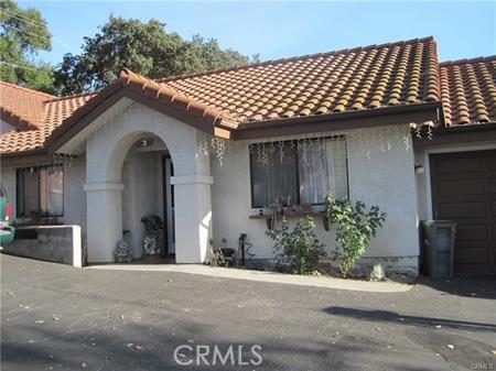 mediterranean / spanish-style house featuring a garage, stucco siding, and a tile roof