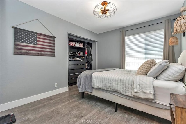 bedroom featuring a closet, baseboards, visible vents, and wood finished floors