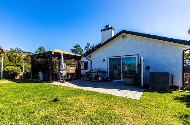 back of property featuring a gazebo, a yard, a patio, and a chimney