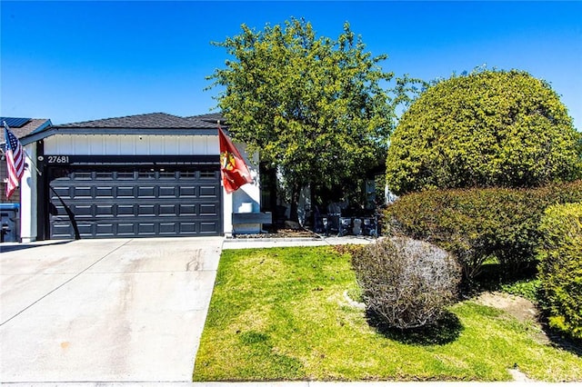 view of front of property featuring a front yard, an attached garage, and driveway