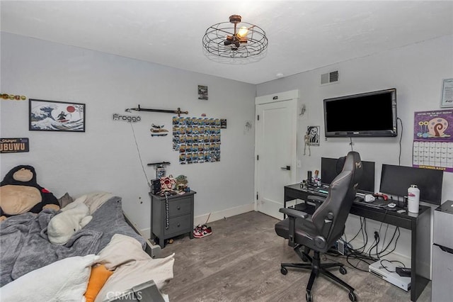 home office featuring visible vents, baseboards, and wood finished floors