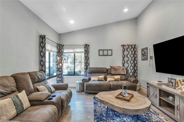 living area with vaulted ceiling, recessed lighting, light wood-style floors, and baseboards