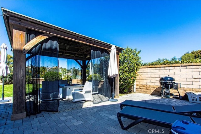 view of patio / terrace with a gazebo, a fenced backyard, and grilling area