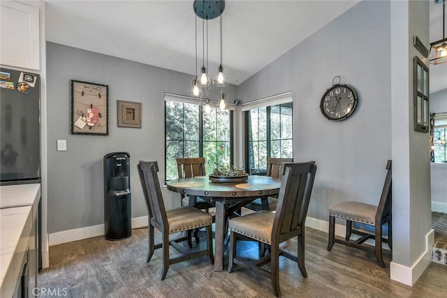 dining space with vaulted ceiling, baseboards, and dark wood-style flooring