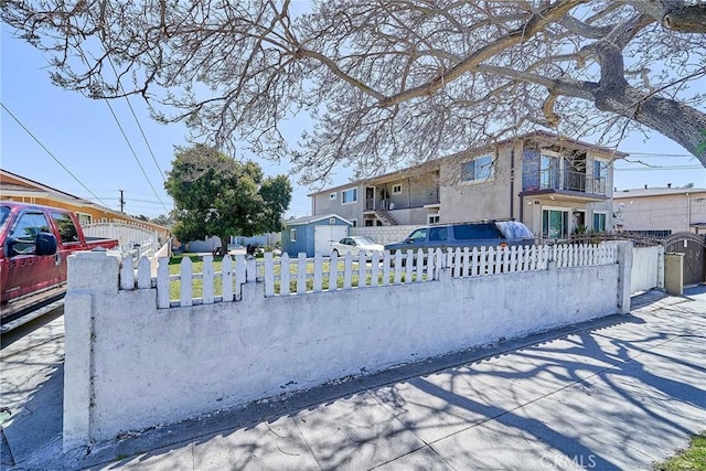 exterior space featuring a fenced front yard and a balcony