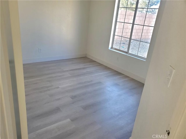 unfurnished room featuring baseboards and wood finished floors