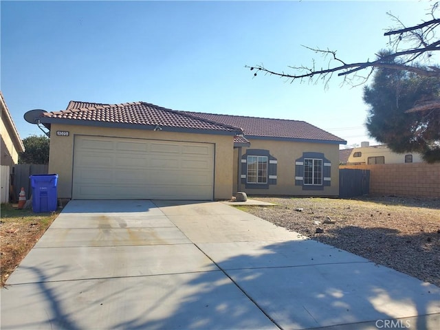 mediterranean / spanish home with stucco siding, a garage, concrete driveway, and a tile roof