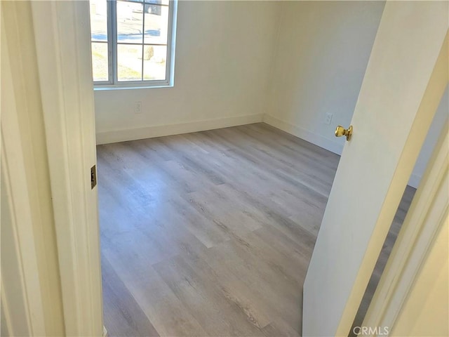 unfurnished room featuring baseboards and wood finished floors