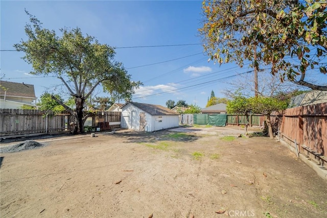 view of yard featuring a storage unit, an outdoor structure, and a fenced backyard