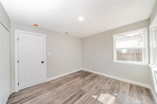 unfurnished room with visible vents, baseboards, and light wood-style floors