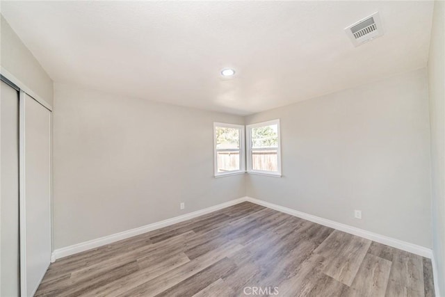 empty room featuring visible vents, baseboards, and light wood-style floors