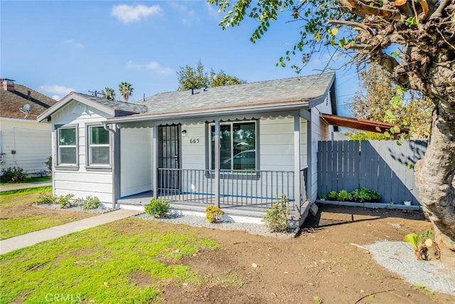 bungalow-style house featuring covered porch and fence