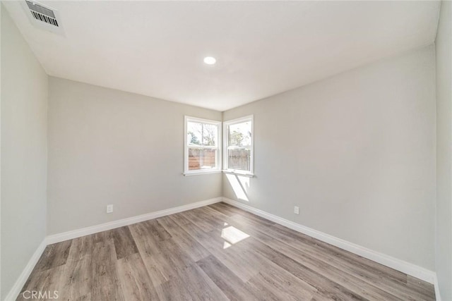 unfurnished room with recessed lighting, visible vents, baseboards, and wood finished floors