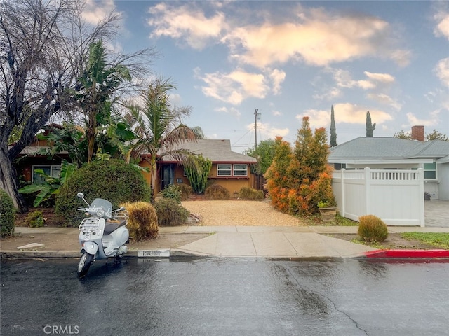 view of front of house with uncovered parking and fence