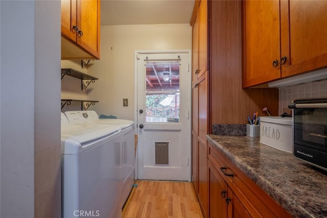 washroom featuring a toaster, light wood-style floors, cabinet space, and washing machine and clothes dryer