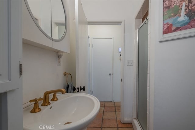 full bathroom featuring tile patterned flooring, a shower stall, and a sink