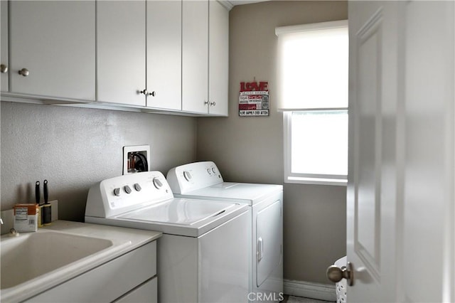 washroom featuring a sink, cabinet space, and independent washer and dryer