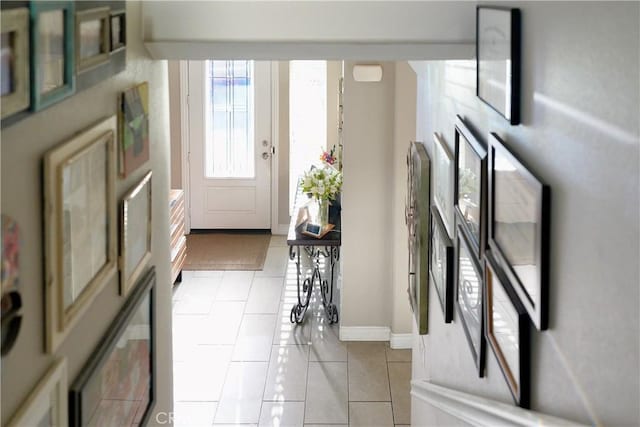 foyer with light tile patterned floors and baseboards