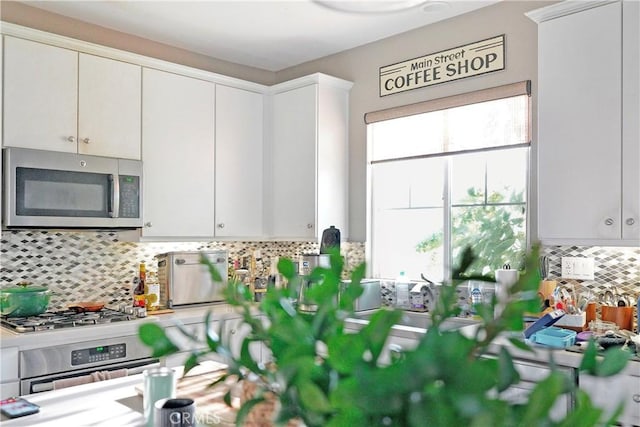 kitchen featuring light countertops, white cabinets, tasteful backsplash, and appliances with stainless steel finishes