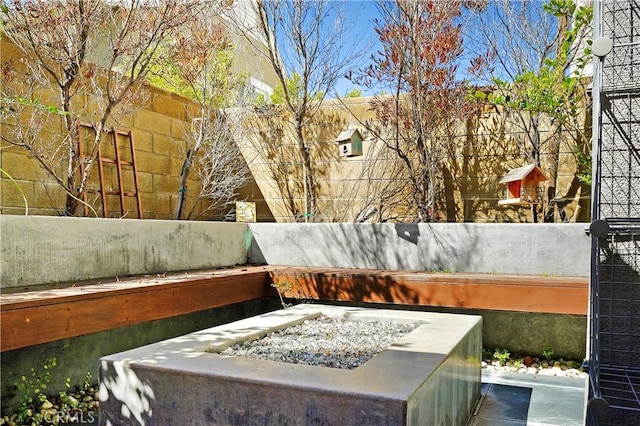 view of patio featuring a fire pit and fence