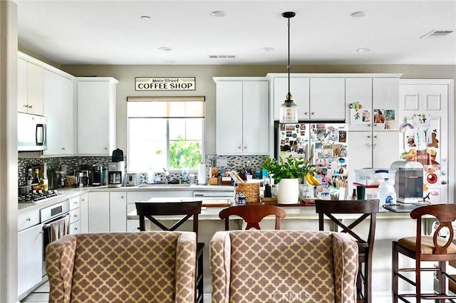 kitchen featuring tasteful backsplash, visible vents, appliances with stainless steel finishes, and light countertops