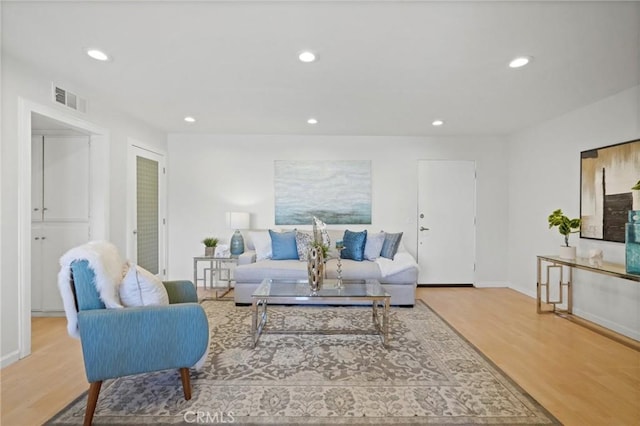 living room featuring recessed lighting, wood finished floors, visible vents, and baseboards