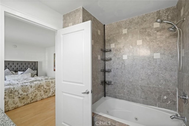 ensuite bathroom featuring ensuite bathroom, a combined bath / shower with jetted tub, and wood finished floors