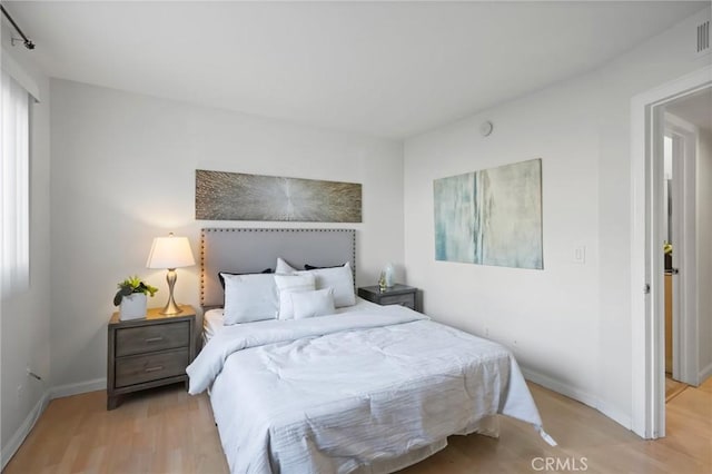 bedroom with visible vents, baseboards, and light wood-style floors