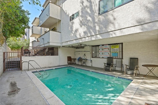 community pool featuring a patio area and stairs