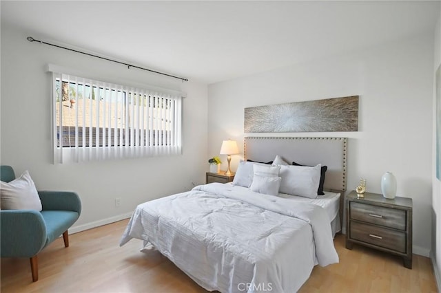 bedroom with baseboards and light wood finished floors