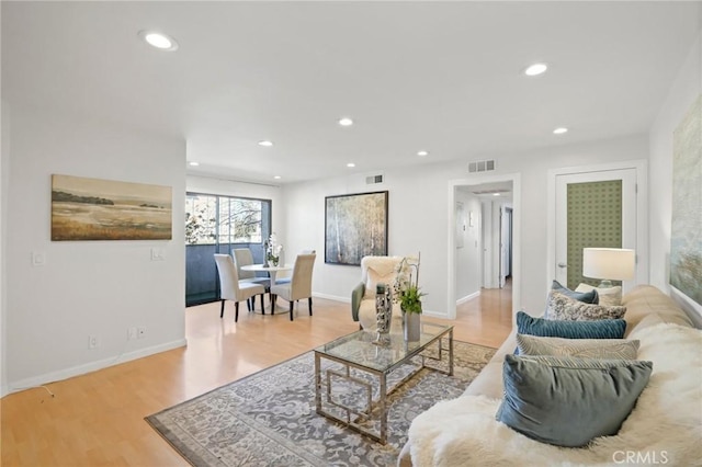 living room featuring light wood-style flooring, recessed lighting, and visible vents