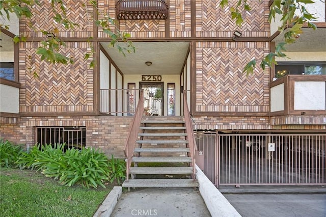 property entrance with stucco siding and brick siding