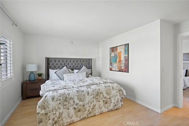 bedroom featuring baseboards and wood finished floors