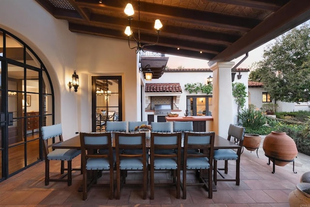 view of patio with outdoor dining space, a grill, and exterior kitchen