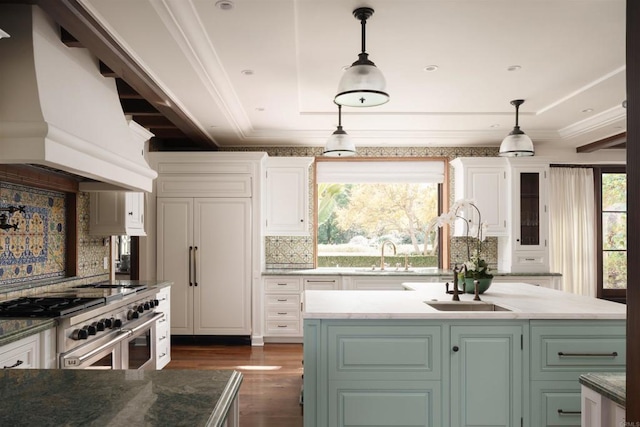 kitchen with white cabinets, ornamental molding, custom range hood, and range with two ovens