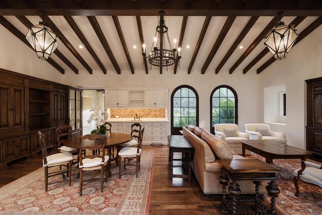 dining space with dark wood finished floors, a notable chandelier, and high vaulted ceiling